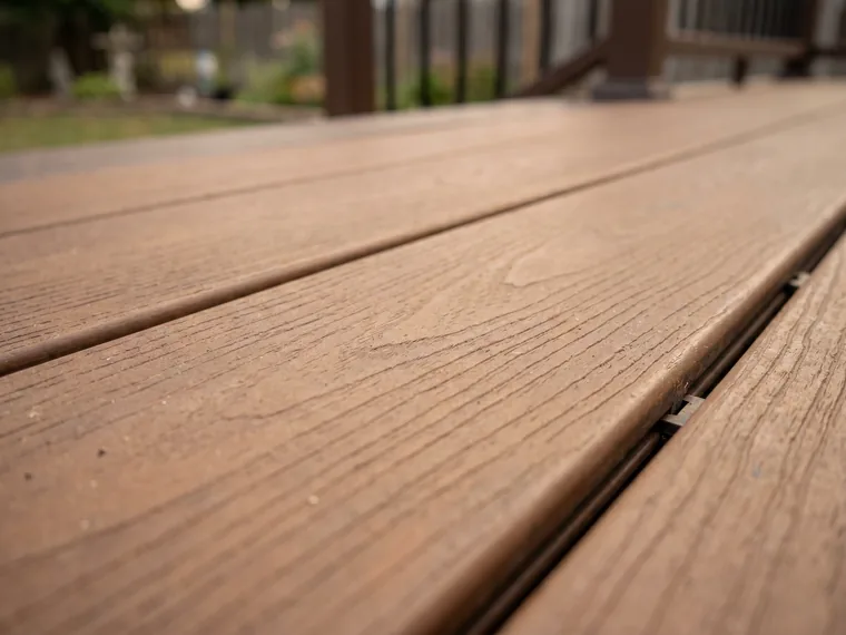 Composite deck boards with woodgrain texture