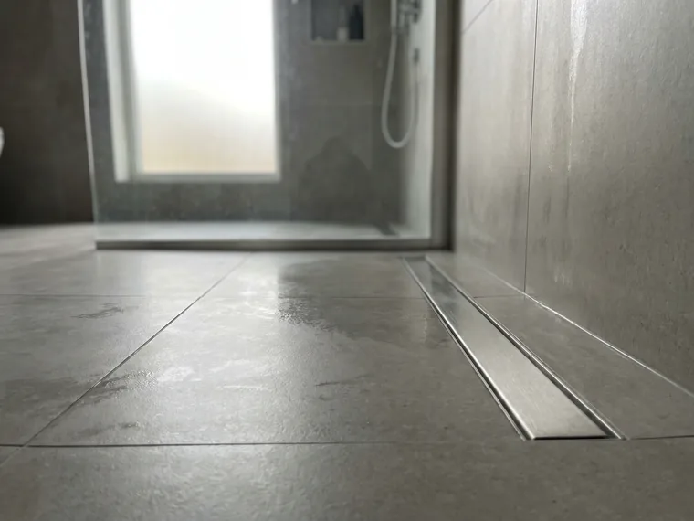 Curbless shower entry with linear channel drain